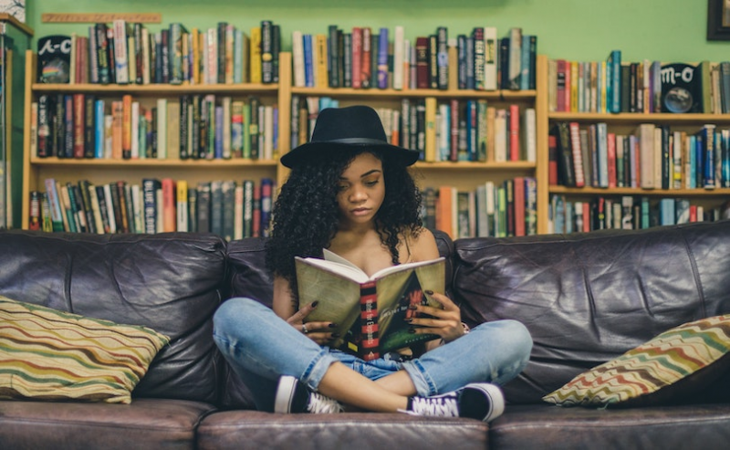 Girl sitting on sofa with book