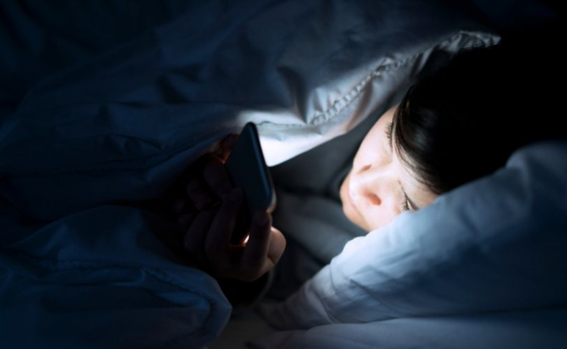Man on phone under duvet