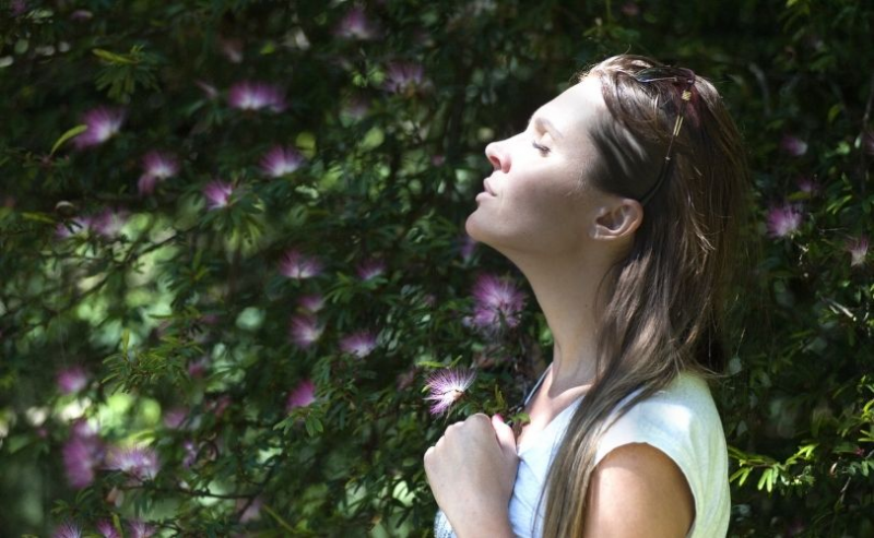 Woman facing sun with eyes closed