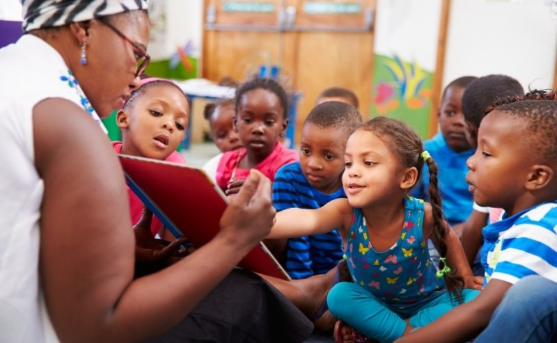 A teacher showing children a book