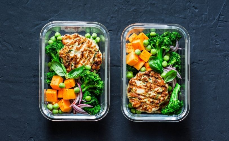 Two lunchboxes full with chicken and avocado