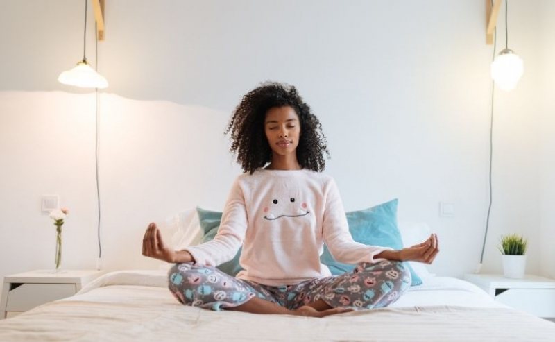 Woman meditating on bed